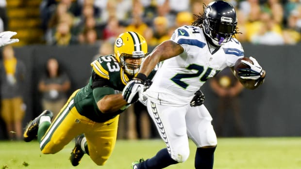 Sep 20, 2015; Green Bay, WI, USA; Seattle Seahawks running back Marshawn Lynch (24) tries to break free from Green Bay Packers linebacker Nick Perry (53) in the second quarter at Lambeau Field.
